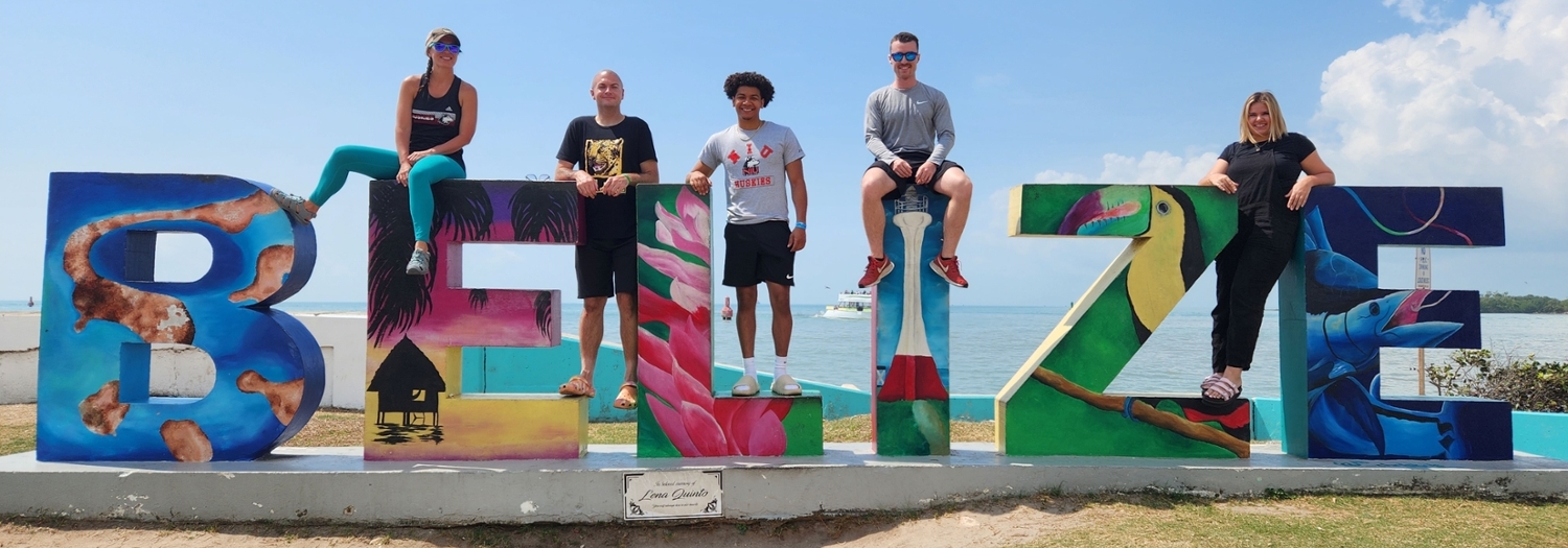 Students sitting on sign in Belize