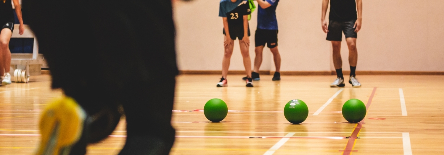 Green balls in a row on a gym floor